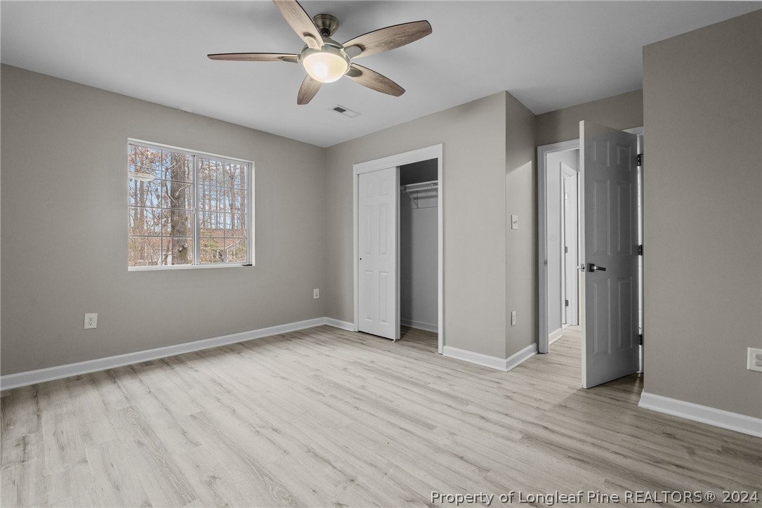 7039 Pine Road Sanford, NC 27332 - Photo 22 of 35 an empty room with wooden floor ceiling fan and windows