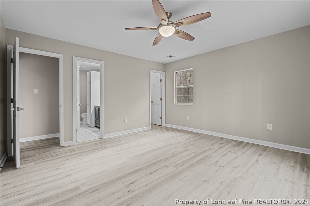 7039 Pine Road Sanford, NC 27332 - Photo 29 of 35 an empty room with wooden floor and ceiling fan
