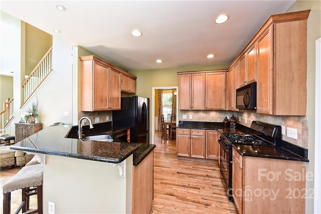 7115 Ramsgate Road Charlotte, NC 28270 - Photo 14 of 39 a kitchen with granite countertop kitchen island stainless steel appliances a sink stove and refrigerator