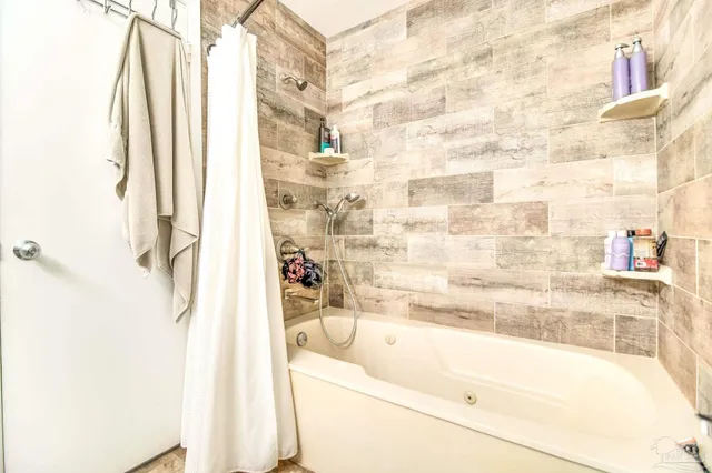 a bathroom with bathtub and shower