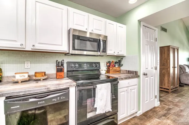 a kitchen with stainless steel appliances granite countertop a stove a microwave and a refrigerator