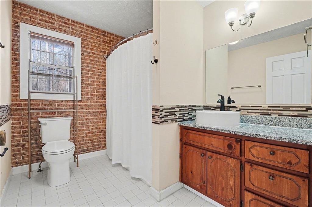 5295 Ridge Road Douglasville, GA 30134 - Photo 19 of 35 a bathroom with a granite countertop sink a toilet and a mirror