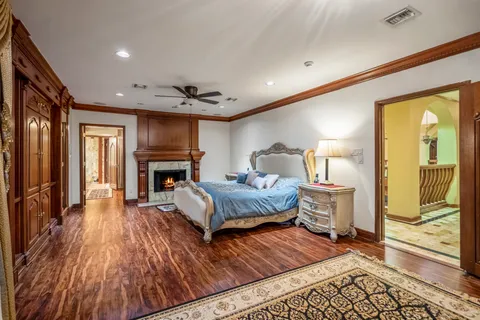 a spacious bedroom with a bed and wooden floor