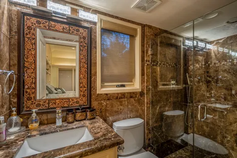 a bathroom with a toilet sink vanity and mirror