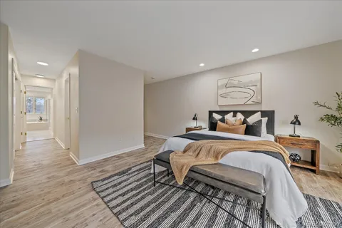 a bedroom with a bed and wooden floor