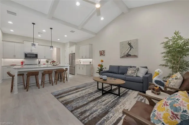 a living room with lots of furniture and kitchen view