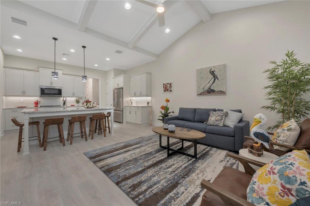 7239 Saona Court Naples, FL 34113 - Photo 1 of 12 a living room with lots of furniture and kitchen view