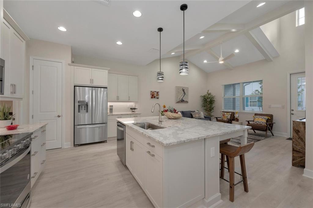 7239 Saona Court Naples, FL 34113 - Photo 5 of 12 a kitchen with a refrigerator a sink and a stove