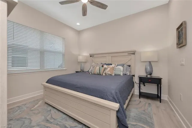 a bed sitting in a bedroom next to a window and a chandelier