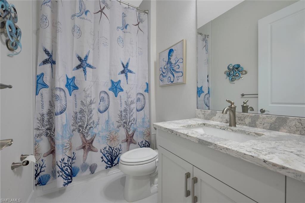 7239 Saona Court Naples, FL 34113 - Photo 9 of 12 a bathroom with a granite countertop sink and a mirror