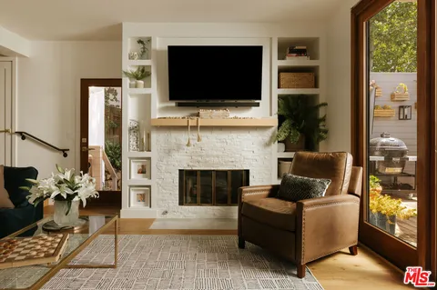 a living room with furniture a flat screen tv and a fireplace