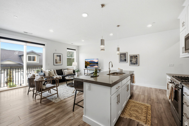 3355 Santa Fe Road Park City, UT 84098 - Photo 9 of 45 Open-concept living space featuring wood-finish flooring, recessed lighting, and a sliding glass door leading to a balcony with black railings