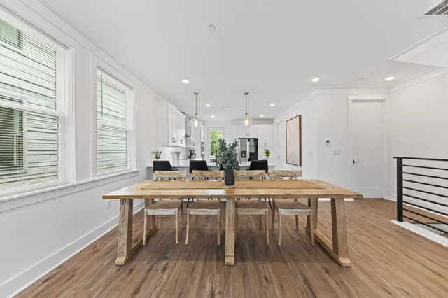 a kitchen with stainless steel appliances a dining table chairs and wooden floor