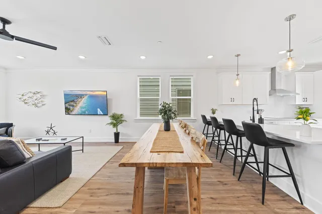 a living room with furniture a wooden floor and kitchen view