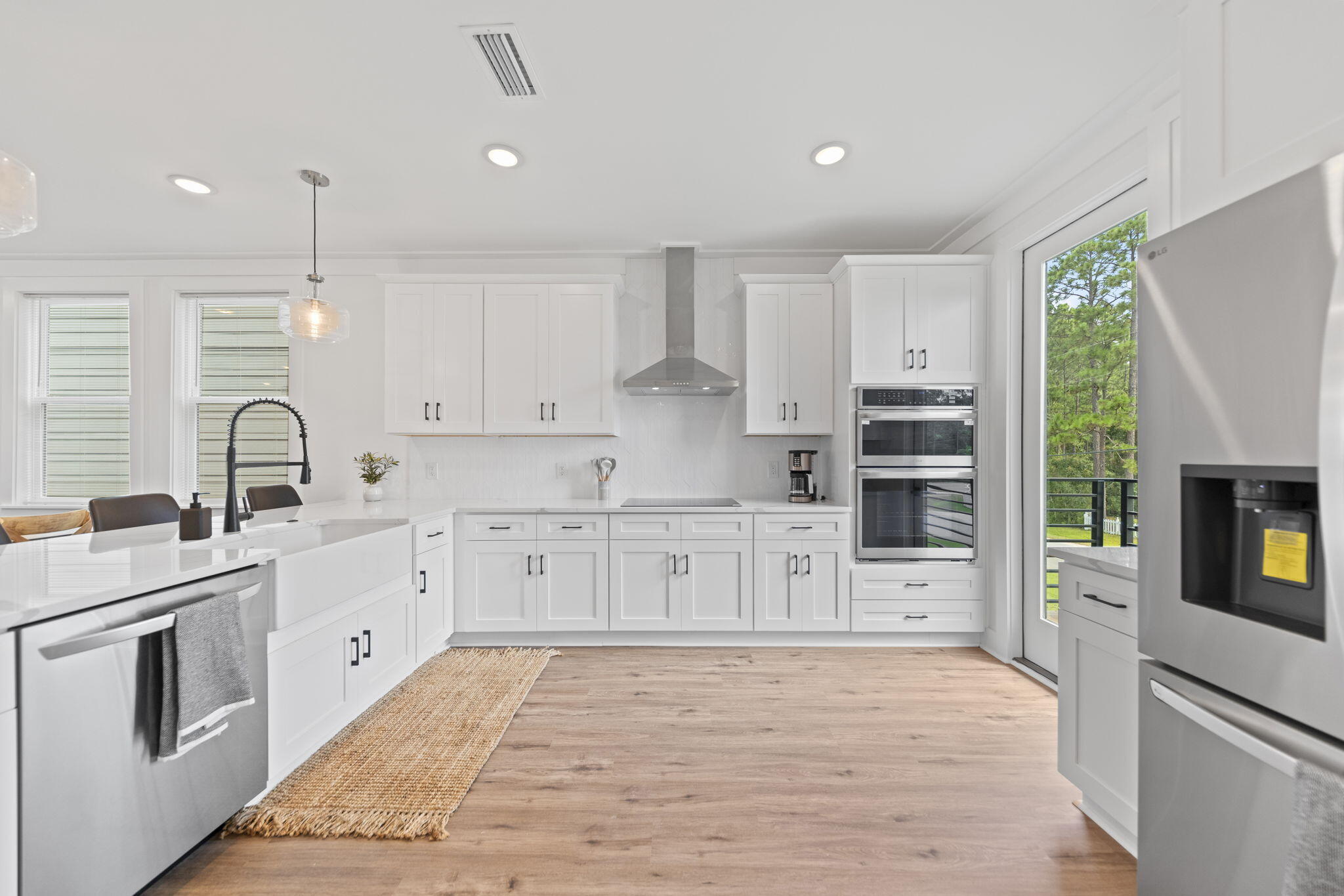 50 Blue Eden Loop, Unit LOT 39 Santa Rosa Beach, FL 32459 - Photo 16 of 46 a large kitchen with stainless steel appliances granite countertop a stove top oven a sink a refrigerator and white cabinets with wooden floor