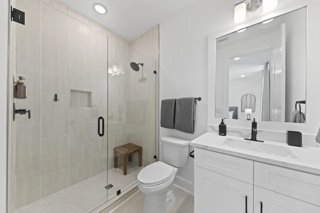 a bathroom with a toilet sink shower and mirror