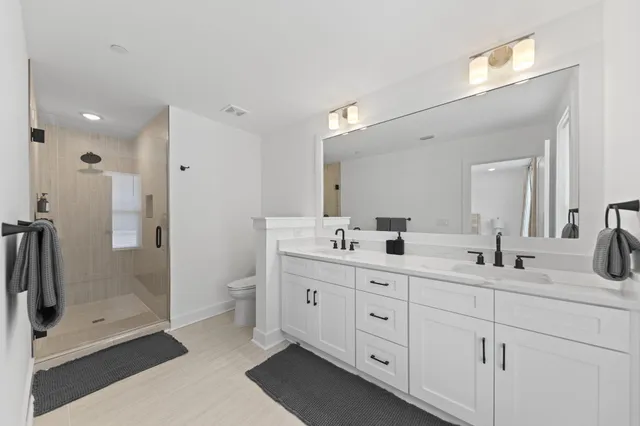 a bathroom with a double vanity sink mirror double and shower