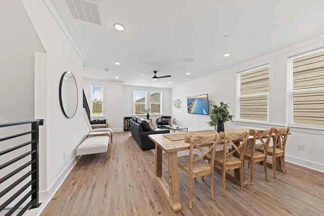 a living room with furniture a large window and wooden floor