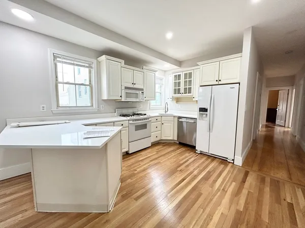 a kitchen with white cabinets and white appliances