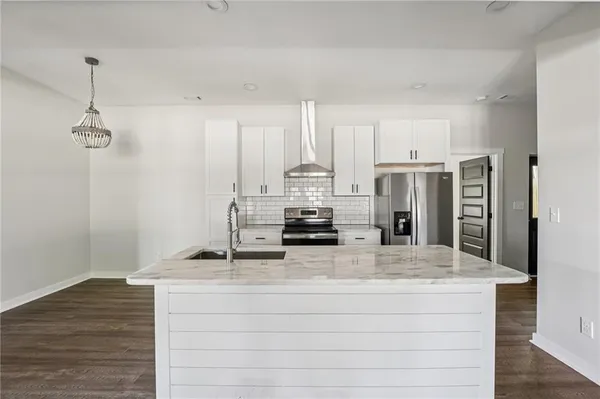 a kitchen with stainless steel appliances granite countertop a sink cabinets and wooden floor