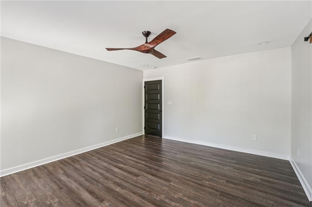 212 Hamilton Avenue Bremen, GA 30110 - Photo 30 of 65 a view of an empty room with wooden floor and a ceiling fan