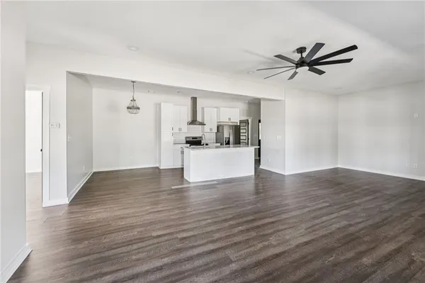 a view of kitchen with cabinets stainless steel appliances and wooden floor