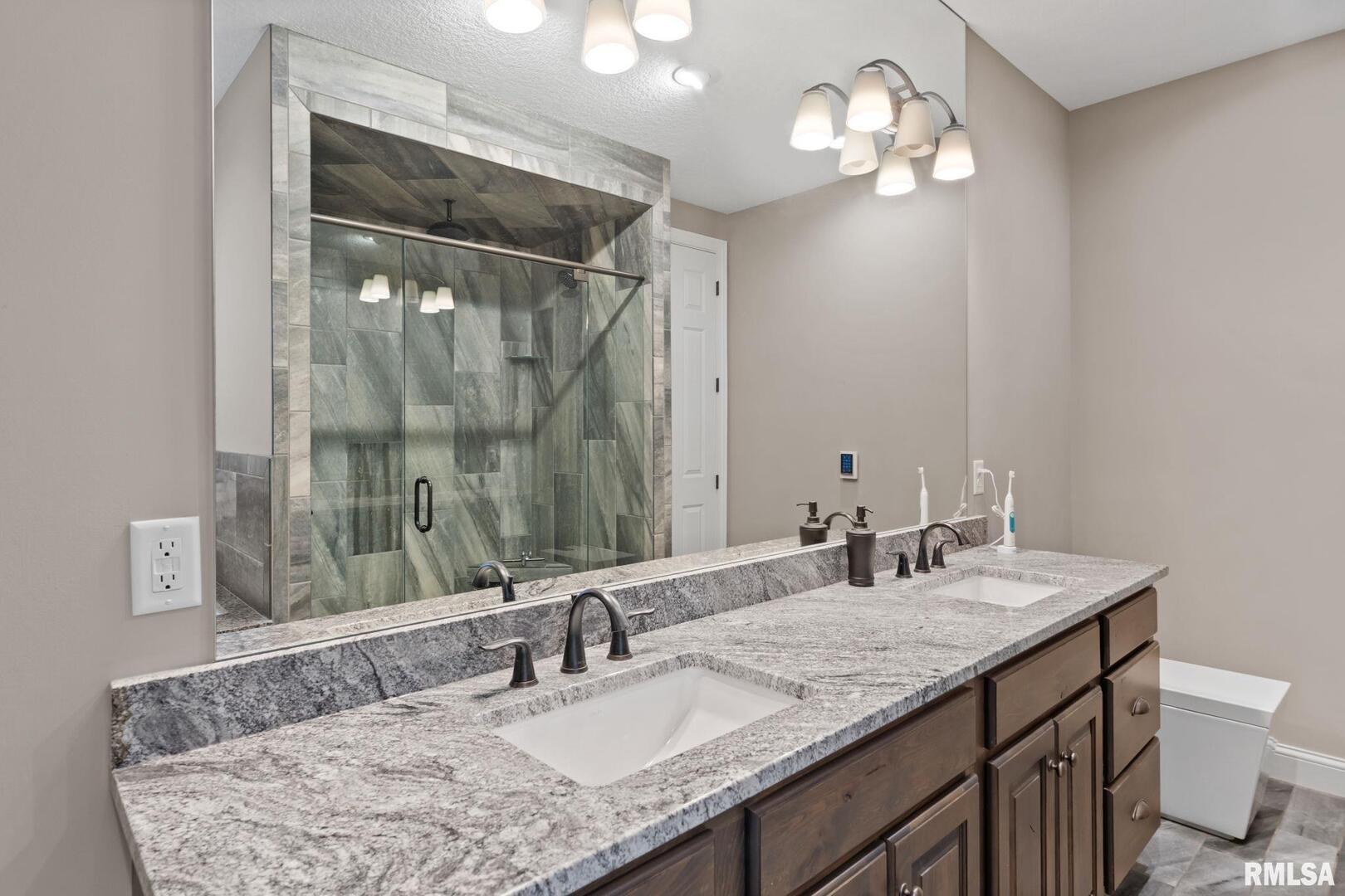 1422 Racine Court Davenport, IA 52804 - Photo 20 of 53 a bathroom with double vanity sinks a vanity a lamp and a mirror
