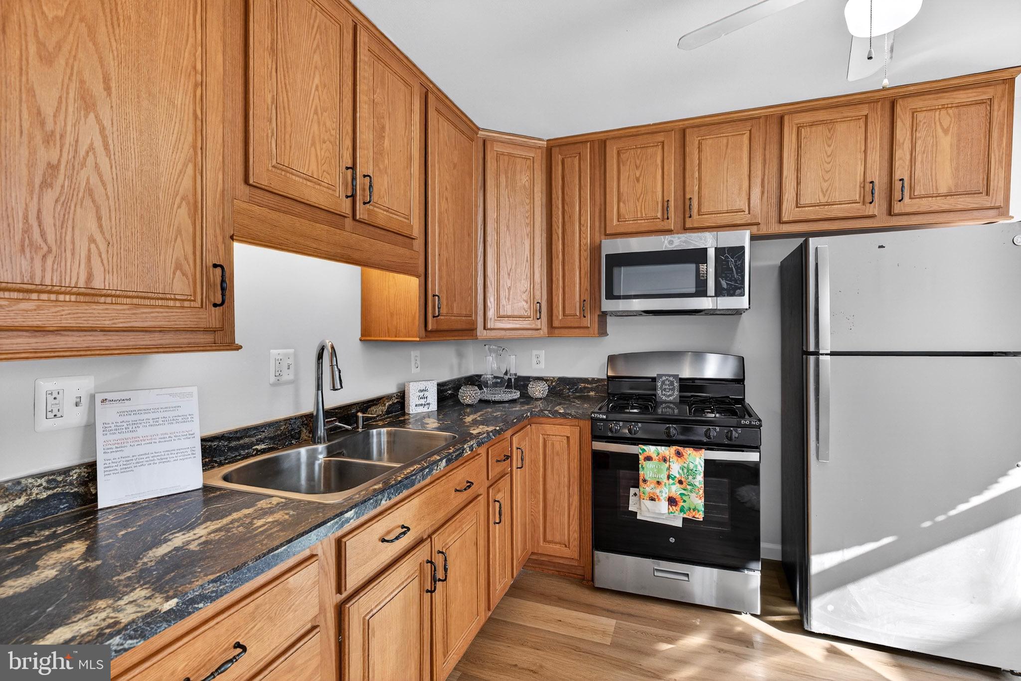1112 Hamilton Street Northeast Washington, DC 20011 - Photo 12 of 34 a kitchen with stainless steel appliances granite countertop a refrigerator stove sink and cabinets