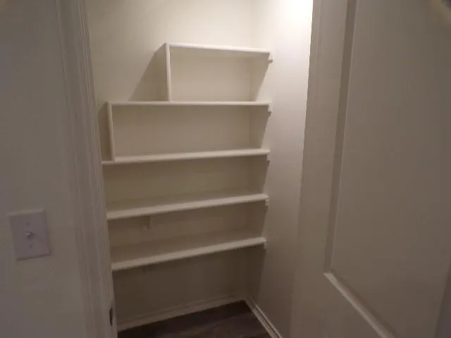 a view of walk in closet with empty racks
