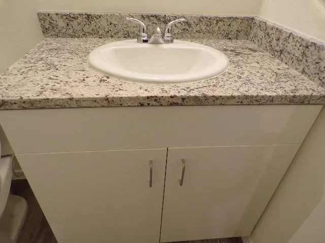 a bathroom with a granite countertop sink and a mirror