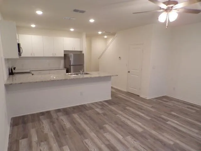 a view of a kitchen with a sink and a ceiling fan