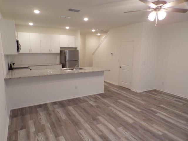 709 South 5th Street, Unit 2 Bonham, TX 75418 - Photo 6 of 32 a view of a kitchen with a sink and a ceiling fan