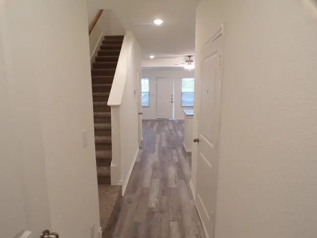 a view of a hallway with wooden floor and staircase
