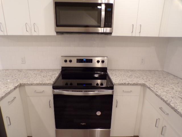 709 South 5th Street, Unit 2 Bonham, TX 75418 - Photo 9 of 32 a stove top oven sitting inside of a kitchen