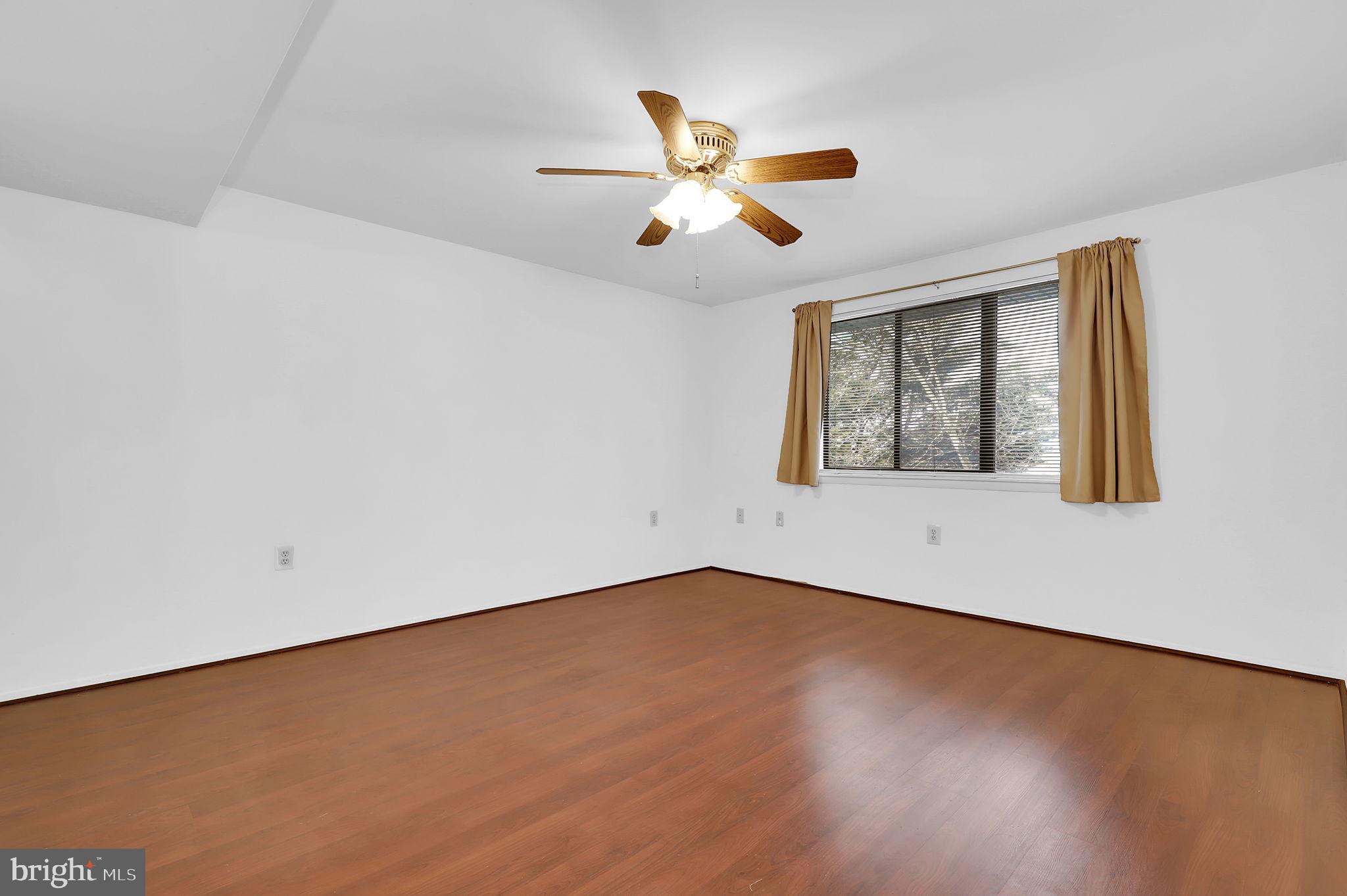 19625 Gunners Branch Road, Unit 932 Germantown, MD 20876 - Photo 17 of 21 a view of an empty room with wooden floor and a window