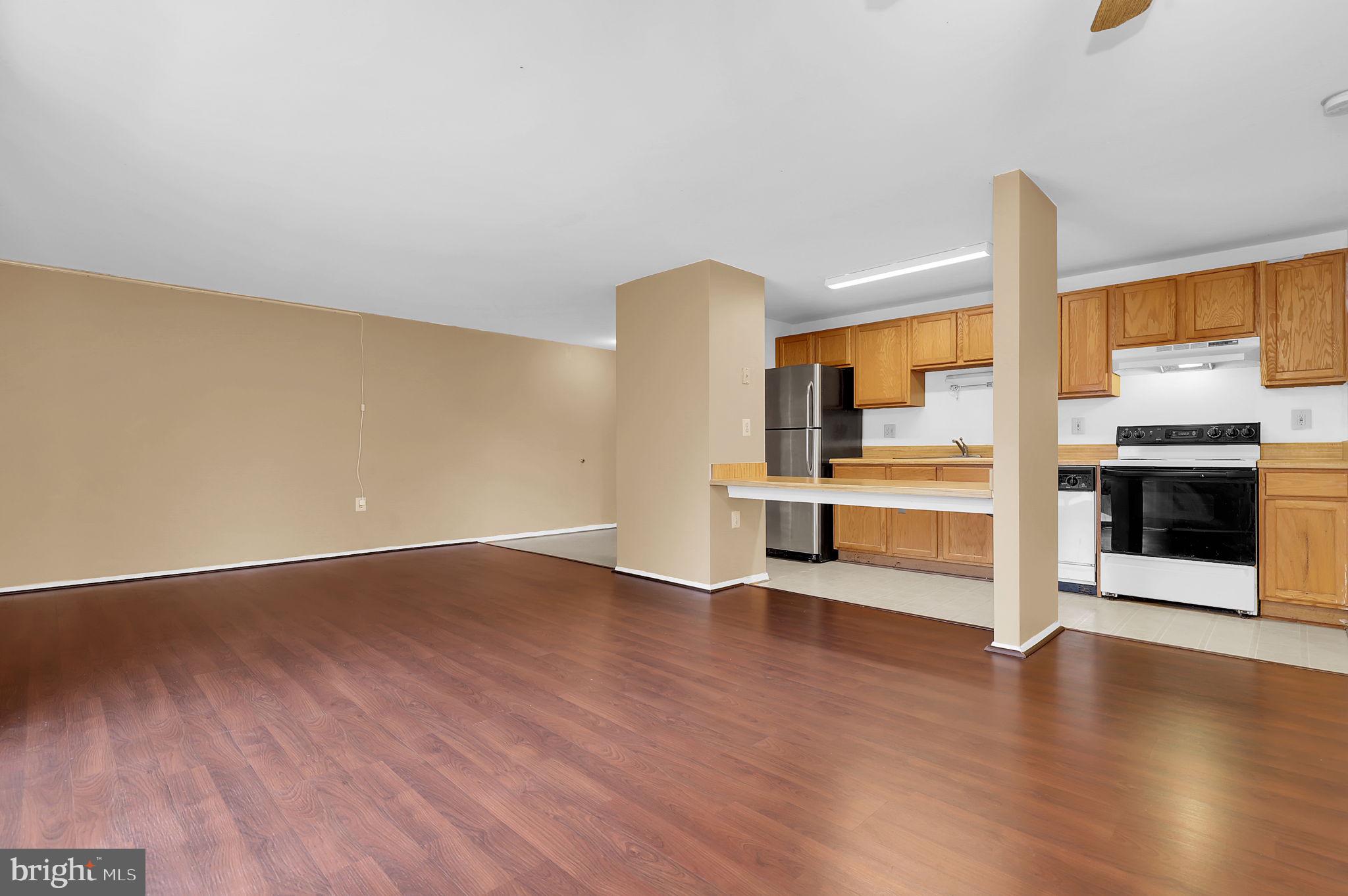 19625 Gunners Branch Road, Unit 932 Germantown, MD 20876 - Photo 5 of 21 an empty room with wooden floor and fireplace