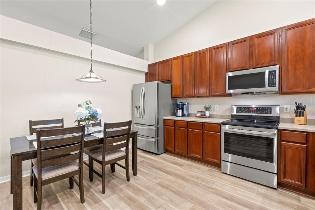 734 Berry Bramble Drive Brandon, FL 33510 - Photo 15 of 49 a kitchen with a stove a microwave and wooden floor