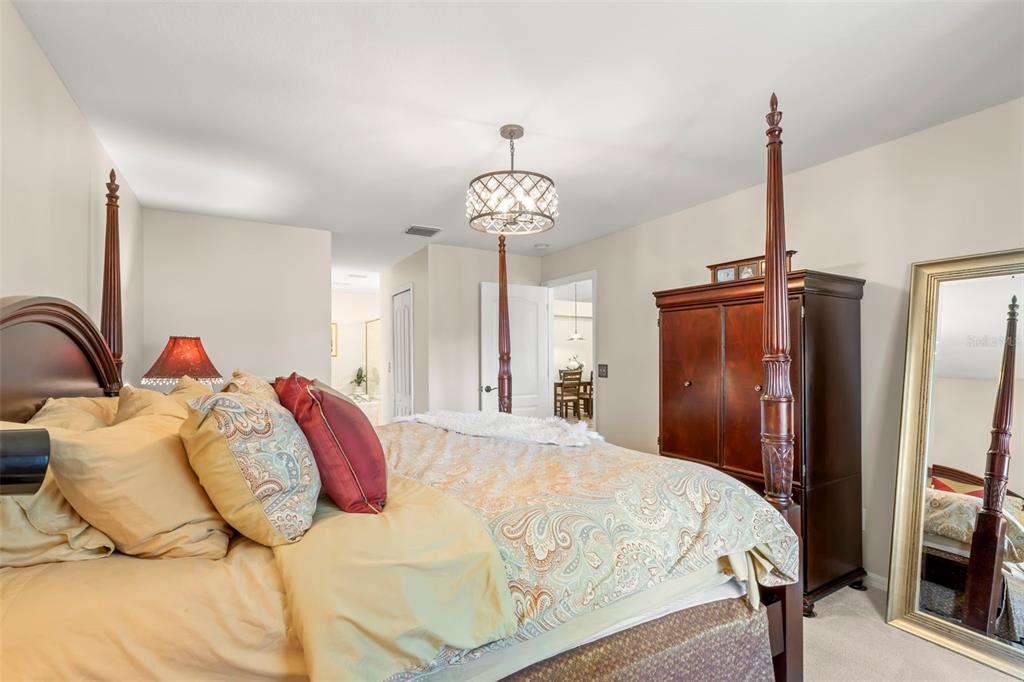 734 Berry Bramble Drive Brandon, FL 33510 - Photo 29 of 49 a bedroom with a bed and a chandelier