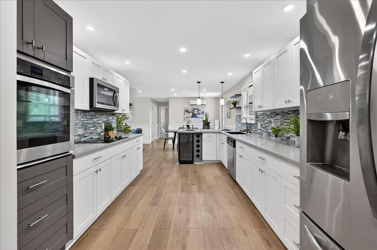 262 Easy Street Sebastian, FL 32958 - Photo 12 of 36 a large kitchen with stainless steel appliances kitchen island granite countertop a stove a sink and a refrigerator