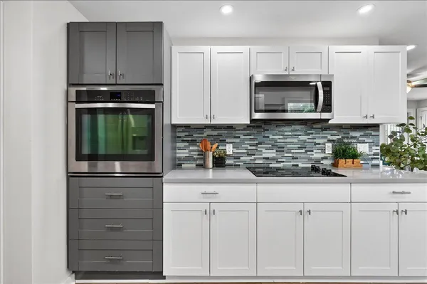 a kitchen with white cabinets and appliances
