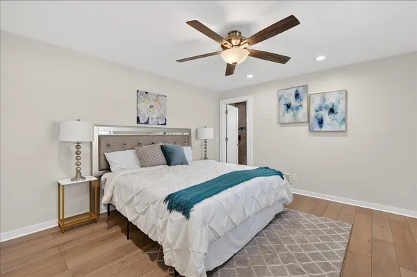 a bedroom with a large bed and a chandelier