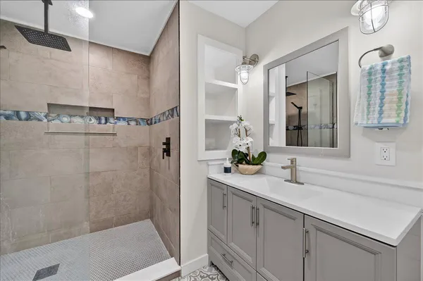 a bathroom with a sink a mirror and a shower