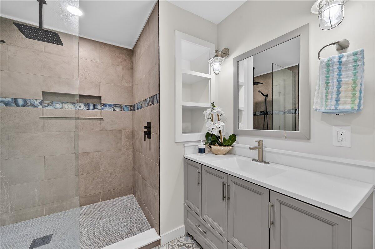 262 Easy Street Sebastian, FL 32958 - Photo 19 of 36 a bathroom with a sink a mirror and a shower