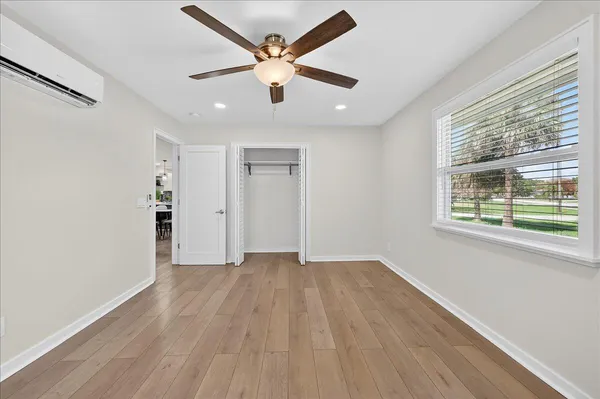 an empty room with wooden floor and windows