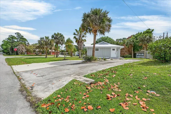 a front view of a house with a yard and trees