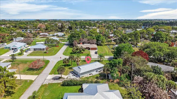 an aerial view of residential houses with outdoor space and trees