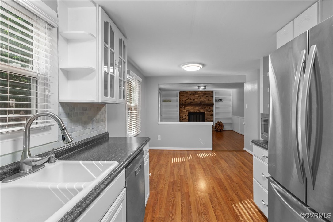 a kitchen with kitchen island a sink wooden floor and stainless steel appliances