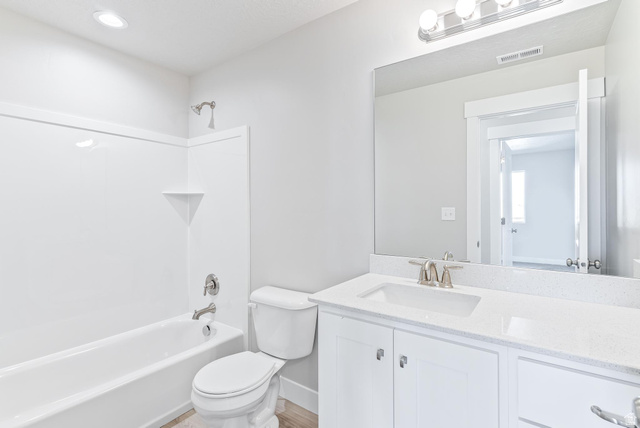 387 Slant Road, Unit 30 Spanish Fork, UT 84660 - Photo 23 of 25 Bright bathroom featuring a white vanity with an integrated sink, a large mirror, and a full bathtub with a shower combination