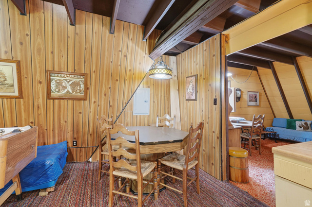 8505 South Snake Crk Road Salt Lake City, UT 84121 - Photo 15 of 67 Wood-paneled interior featuring exposed ceiling beams and a hanging light fixture