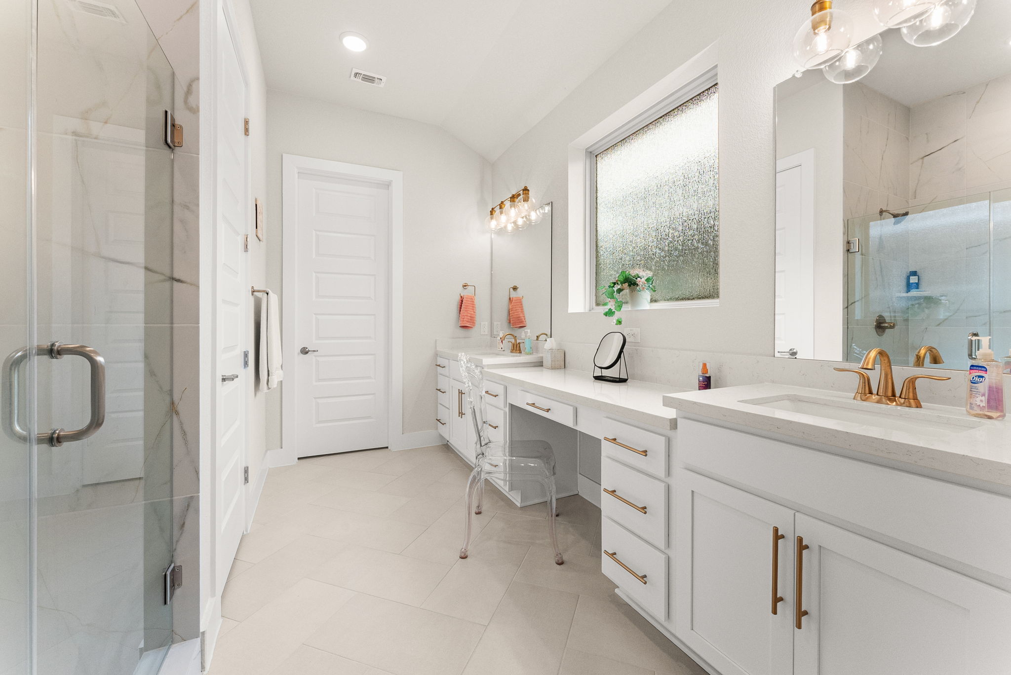 9508 Hamadryas Drive Austin, TX 78744 - Photo 18 of 40 The master bathroom has herringbone tile flooring, multi-height vanity with two sinks, a frameless shower with bench, water closet, and rainfall window.